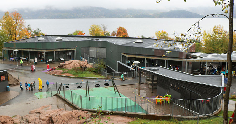 Støa barnehage med lekeplass og fjorden bak